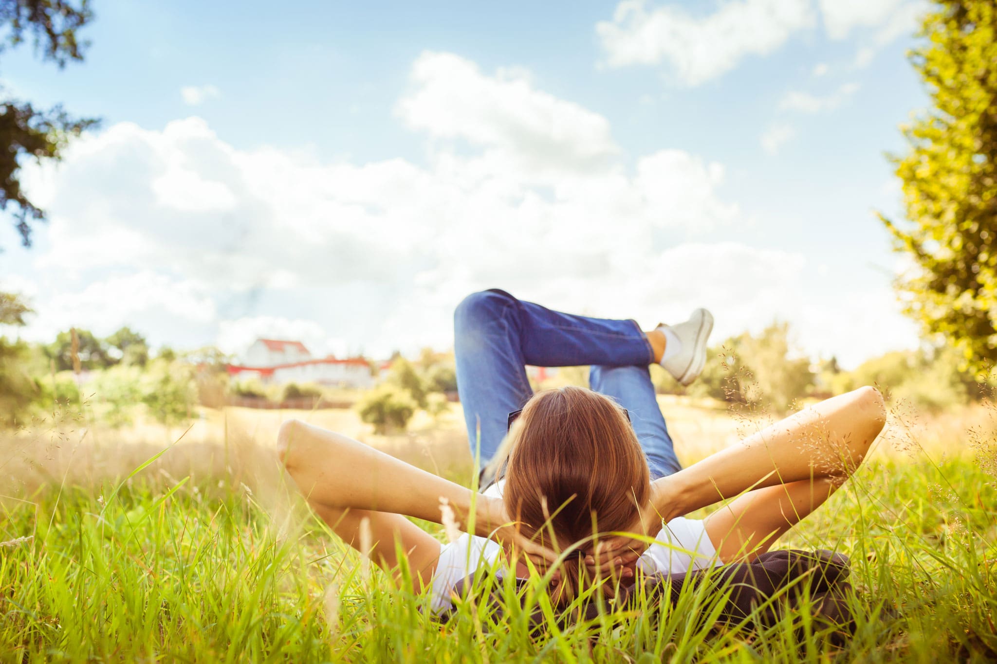 A woman laying on the ground in a green space